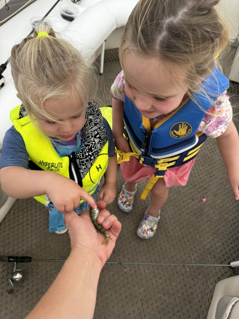 Two children looking at a small fish